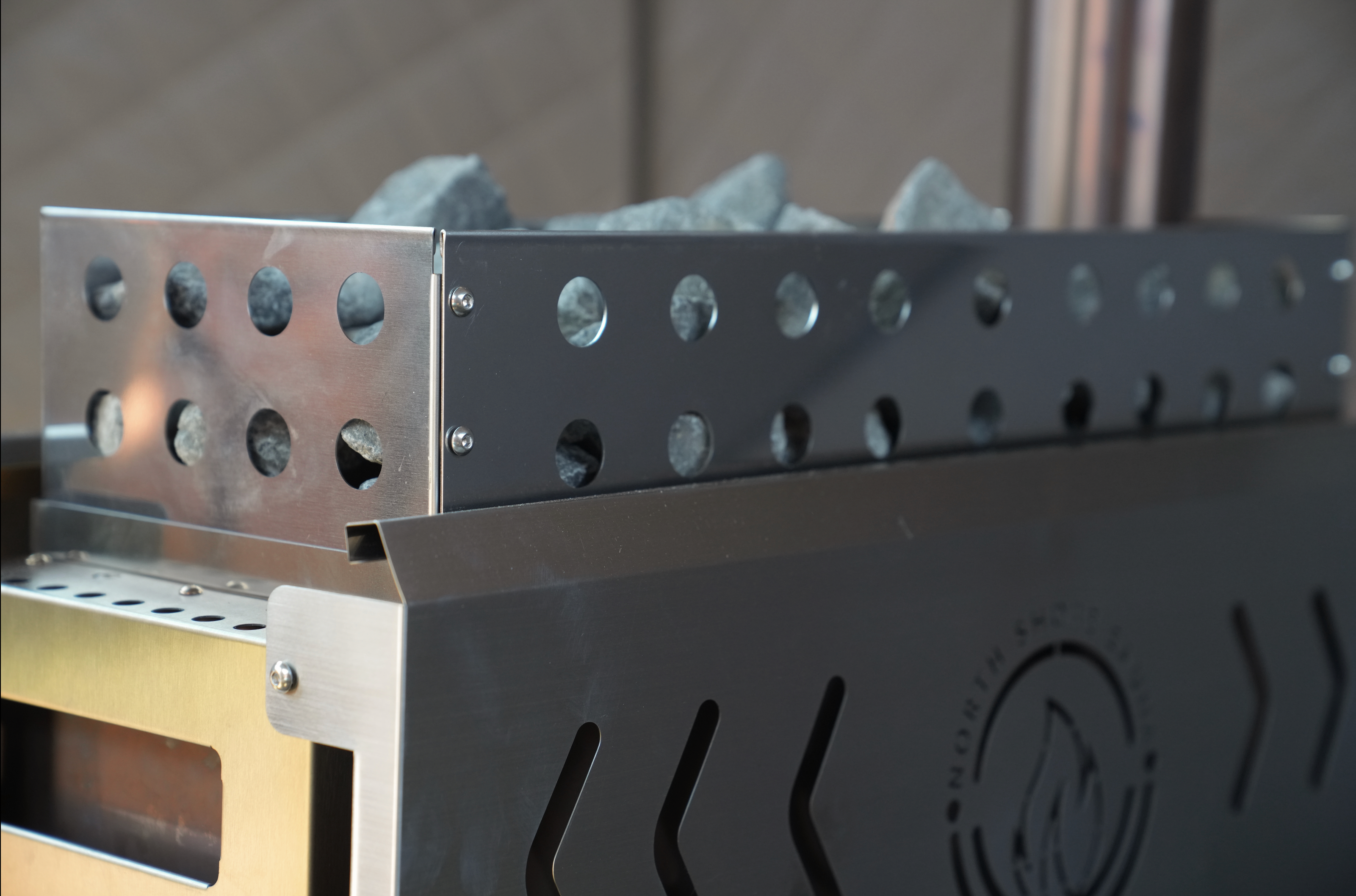 Close-up of a metal grill with a brand logo on a blurred background